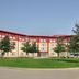 Residence & Conference Centre - Oakville exterior with curved facade, lawn and trees