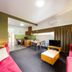 Tall Timbers Tasmania in Smithton living area with pink sofas, TV, dining table and kitchenette