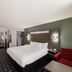 Quality Inn & Suites Irving Dfw Airport South room with king bed and red armchair