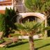 Hazienda Apartmenthotel in Gernsbach courtyard with lounge chairs, palms, and arched balcony