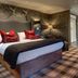 Eglinton Arms Hotel in Glasgow bedroom with plaid carpet, patterned wallpaper and red accent pillows