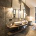 Hotel Bad Fallenbach bathroom with freestanding tub, double sinks and floor-to-ceiling windows in San Leonardo in Passiria