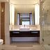 Novotel Lombok Resort & Villas bathroom with double vanity, toilet, and glass-enclosed shower in Kuta