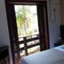 Maratea Mare hotel room in Florianopolis with balcony door and tropical palm view