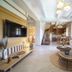 Asion Lithos in Kato Asites living room with stone walls, staircase, TV, and sofa seating