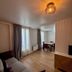Villa Montmartre in Paris: renovated apartment-style room with sofa, dining table, and tall windows