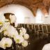 Hotel Zamek Lubliniec meeting room with arched brick ceiling, rows of chairs, and orchid centerpiece