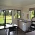 Waitomo Top 10 Holiday Park room with bunk bed, kitchenette, table, and park view in Waitomo