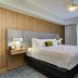 Homewood Suites by Hilton Louisville-East guest room with king bed, bedside lamps and window view in Louisville