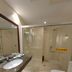 Xinji Garden Hotel in Nanchang bathroom with glass shower, vanity sink, and toilet