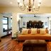Sandton Lodge Rivonia in Johannesburg: elegant lounge with chandelier, sofa, ottoman and polished wood floors