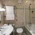 Marygreen Manor Hotel in Brentwood bathroom with bathtub, glass shower screen, toilet and towel rack