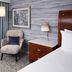 Hilton Washington DC/Rockville Executive Meeting Center guest room with chair, nightstand and bed in Rockville