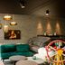 Motel One München-Westend lounge with fireplace, green seating and a decorative wheel in Munich