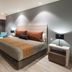 Real Inn Perinorte in Tlalnepantla guest room with king bed, TV, desk, and floor-to-ceiling curtains