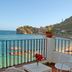 Hotel Lido Mediterranee in Taormina balcony with chair, table, flowers, and sea view of bay and cliffs