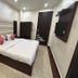 Amrit Villa, New Delhi: compact guest room with double bed, wardrobe, wall-mounted TV and padded headboard