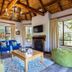 The Cavern in Bonjaneni living room with thatched ceiling, fireplace, large windows and colorful seating