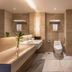 The Greenway Hotel Xiamen bathroom with double sinks, toilet, and marble tile flooring