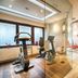 Leonardo Hotel & Residenz München fitness room with cardio machines and mirrored tiled flooring in Munich