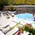 Meli Meli in Thera with a small outdoor pool, sun loungers, and flowering plants