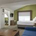 Holiday Inn Express & Suites White River Junction guest room with bed, desk, sofa and seating area