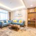 Desheng Hotel Beijing living room with two blue sofas, coffee table, and large window