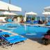 Santa Beach Hotel in Agía Triáda with outdoor pool, blue loungers, umbrellas and sea view