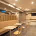 Toyoko Inn Koriyama in Kōriyama lounge with tables, chairs, booths, and a wall-mounted TV
