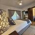 Leopard Corner Lodge in Saint Lucia guest room with king bed, wardrobe and tiled floor