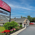 Red Carpet Inn Orchard Park exterior with parking lot, sign, and landscaped entrance