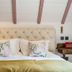 Cotswold Plough Hotel & Restaurant in Bampton guest room with tufted headboard and patterned pillows