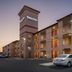Days Inn by Wyndham Fontana / Rialto exterior at dusk with lit rooms and parking lot in Rialto