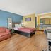 Econo Lodge Charlotte Airport Area room with one bed, sofa, desk, and wood-look flooring in Charlotte.