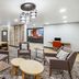 Candlewood Suites Topeka West lobby seating area with modern chairs, tables and patterned carpet