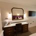 Marygreen Manor Hotel in Brentwood guest room with desk, wall-mounted TV and upholstered chair