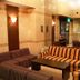 Hiroshima Ekimae Green Hotel lounge in Hiroshima with striped sofas, coffee table and TV