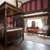 The White Swan Hotel, Stratford-upon-Avon: four-poster bed in a room with patterned walls and window seating.