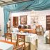 Judita Palace Heritage Hotel in Split dining room with set tables, striped armchairs, and draped turquoise curtains