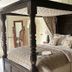 Ravenwood Hall Hotel in Bury St. Edmunds, four-poster bed with floral curtains and bedside lamps