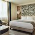 The Phoenicia Malta in Valletta: stylish guest room with king bed, patterned headboard, and fruit display