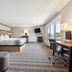 AmericInn by Wyndham Wisconsin Dells guest room with king bed, desk, TV, fireplace and large windows
