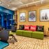ibis Paris Tour Eiffel Cambronne 15ème lounge with green sofa, black chairs and blue shelving in Paris