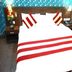 Hotel Daya Continental, New Delhi: double bed with red-striped bedding and floral accents