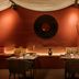 Hotel Dei Cavalieri Caserta dining room with warm red walls, candlelit tables, and decorative wall art