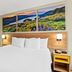 Days Inn by Wyndham Fontana / Rialto room with king bed and scenic landscape wall art