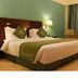 The White Hotel Katra room with king bed, green accents, desk and curtained window in Katra