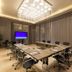 Khalidia Palace Hotel Dubai meeting room with conference table, rolling chairs and large chandelier in Dubai