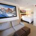 The Historic Crags Lodge in Estes Park guest room with bed, sofa, and mountain artwork