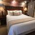 The Historic Crags Lodge guest room in Estes Park with a king bed and rustic wood wall